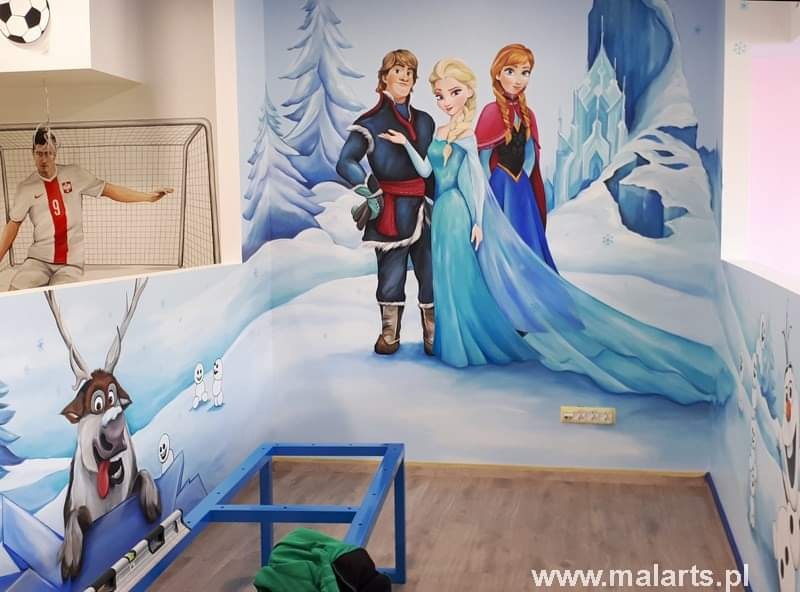 Pokój dziecięcy z ręcznie malowanym muralem przedstawiającym postacie z filmu 'Kraina Lodu', na ścianie widoczny również mural z piłkarzem w stroju reprezentacji Polski i bramką, w pomieszczeniu...