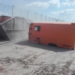 Kontener budowlany poddawany obróbce strumieniowo-ściernej przy użyciu mobilnej piaskarki FAUN VIAJET, z widocznym pyłem w powietrzu.