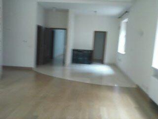 Jasne wnętrze po remoncie: parkiet, białe ściany, drzwi wewnętrzne. Widok na sąsiednie pomieszczenie przez otwarte drzwi. Minimalistyczny wystrój, naturalne światło.