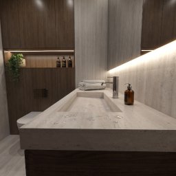 House-Design - Nowoczesna łazienka z długim, beżowym blatem z wbudowaną umywalką, chromowaną baterią i bursztynowym dozownikiem. Ciemne szafki z podświetlaną wnęką, rośliną i butelkami.