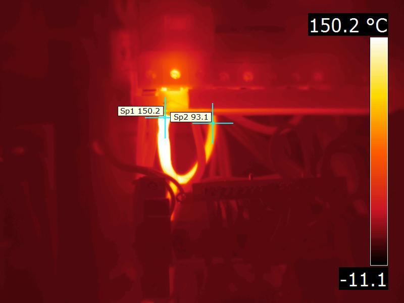 Obraz termowizyjny instalacji elektrycznej z zaznaczonymi punktami pomiarowymi temperatury: 150.2°C i 93.1°C, skala temperatury po prawej stronie.