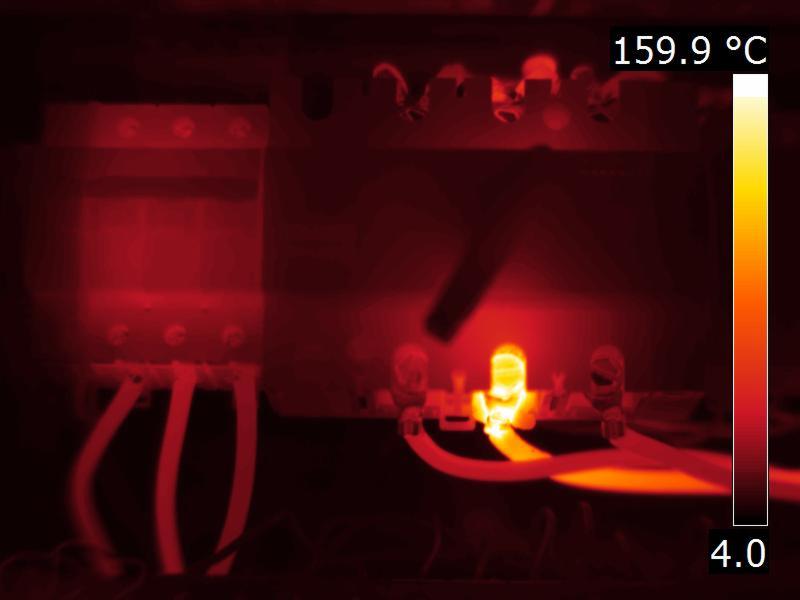 Termowizyjny obraz instalacji elektrycznej, widoczny rozkład temperatur na elementach, skala temperatur po prawej stronie.