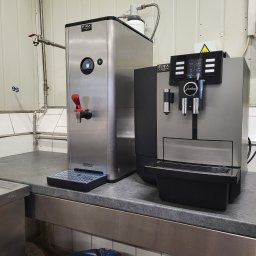 FIRA Robert Firkowski - Profesjonalny ekspres do kawy Jura X6 oraz dystrybutor gorącej wody Bravilor Bonamat Fira, ustawione obok siebie na blacie w Słupsku. Dystrybutor wody ma kranik z czerwoną rączką i wyświetlacz...