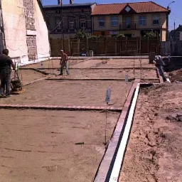 Przygotowanie terenu pod fundamenty z użyciem zagęszczarki w otoczeniu zabudowy miejskiej.