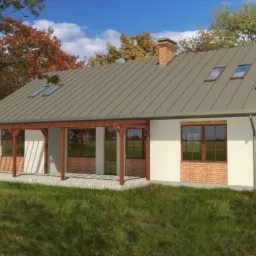 Wizualizacja projektu domu jednorodzinnego z zadaszonym tarasem, elewacja z białego tynku i cegły, szary dach z lukarnami, komin z cegły, otoczenie z zielonego trawnika i drzew.