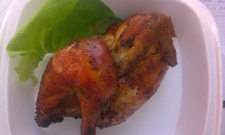 Pieczony kurczak z chrupiącą skórką, podany na białym talerzu z liściem sałaty, widoczne notatki w tle.