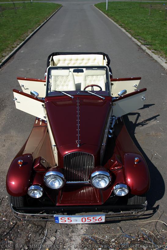 Bordowa limuzyna Nestor Majestic z otwartymi drzwiami, kremowe skórzane wnętrze, widok z góry na asfaltowej drodze.