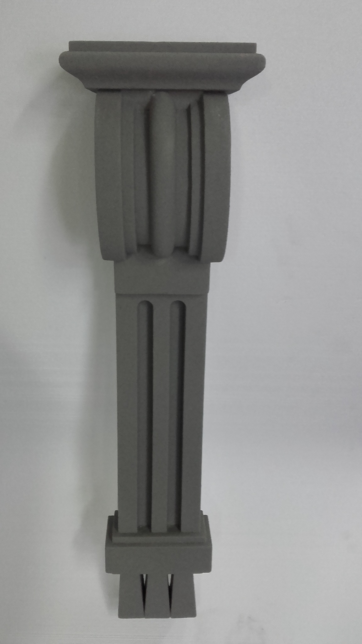 Szara, dekoracyjna kolumna z materiału izolacyjnego, widoczna na jasnym tle.