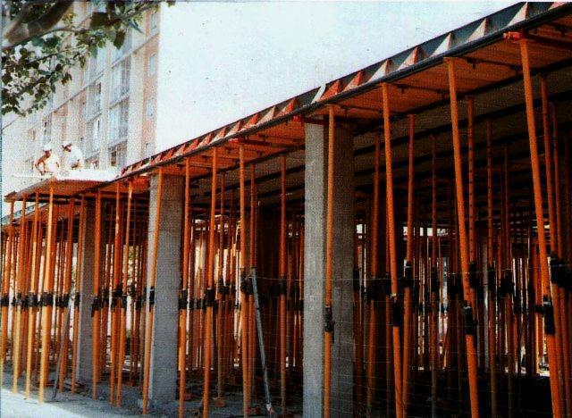 Wznoszenie stropu budynku wielokondygnacyjnego z użyciem systemu szalunków stropowych Forza 2000, widoczne liczne podpory pionowe i deskowanie poziome, dwóch pracowników na górze.