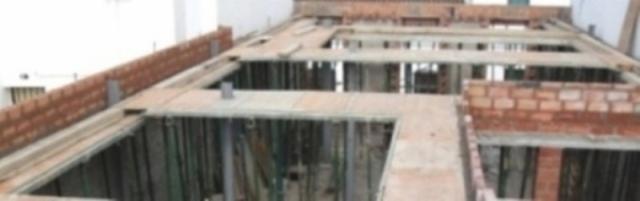 Montaż szalunków stropowych Forza 2000 z widocznymi podporami pionowymi i częściowo wymurowanymi ścianami nośnymi.