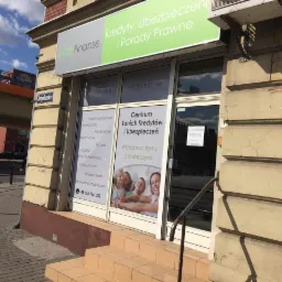 Fasada biura Eco Finanse z szyldem 'Kredyty, Ubezpieczenia i Porady Prawne'. Okna z ofertą kredytów, ubezpieczeń i hasłem 'Współpracujemy z najlepszymi'.