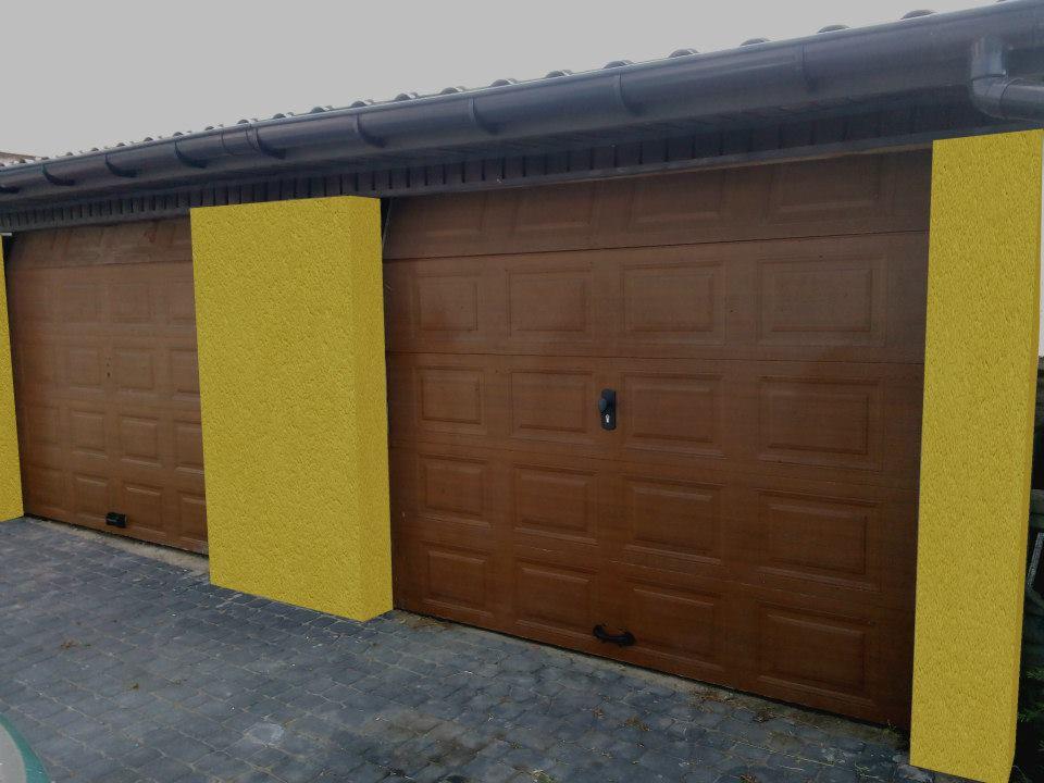 Nowoczesny garaż dwustanowiskowy z brązowymi bramami segmentowymi i żółtymi filarami, widok z zewnątrz na tle szarej kostki brukowej.