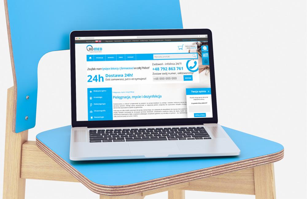 Laptop wyświetlający stronę internetową AD MED na krześle o niebieskim siedzisku i oparciu, prezentacja responsywnego designu.