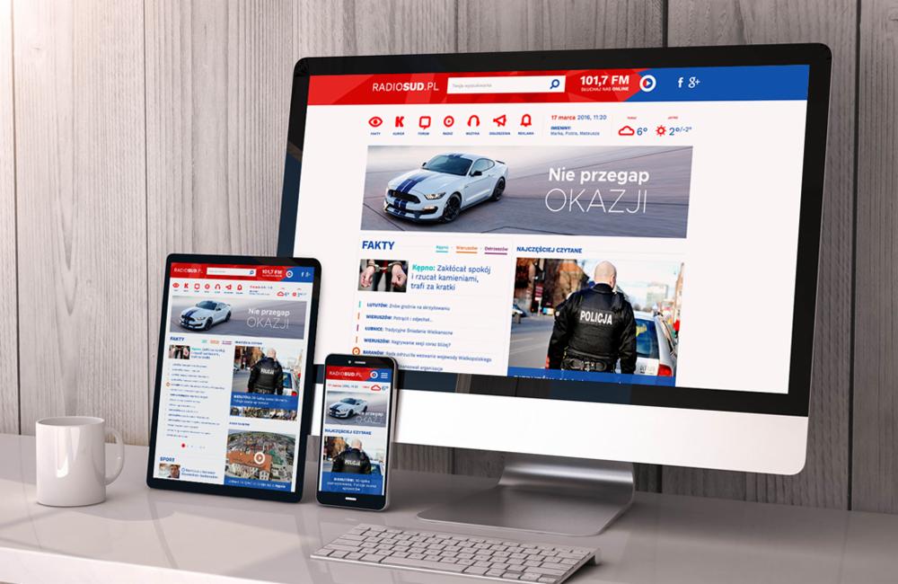 Prezentacja responsywnej strony internetowej radiosud.pl na monitorze, tablecie i smartfonie, obok biały kubek i klawiatura.