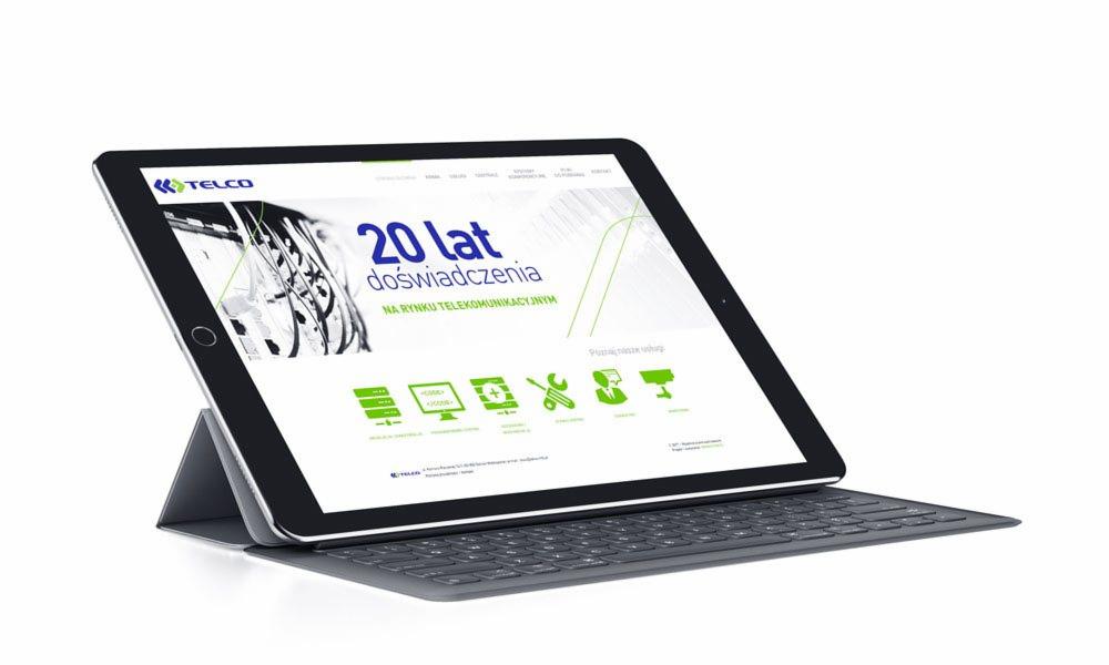 Tablet z wyświetloną stroną internetową firmy telekomunikacyjnej, prezentujący 20 lat doświadczenia.