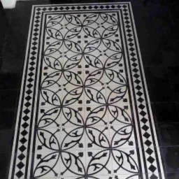 Ułożona podłoga z białych płytek z czarnym wzorem geometrycznym, otoczona czarnymi płytkami w Mysłowicach.