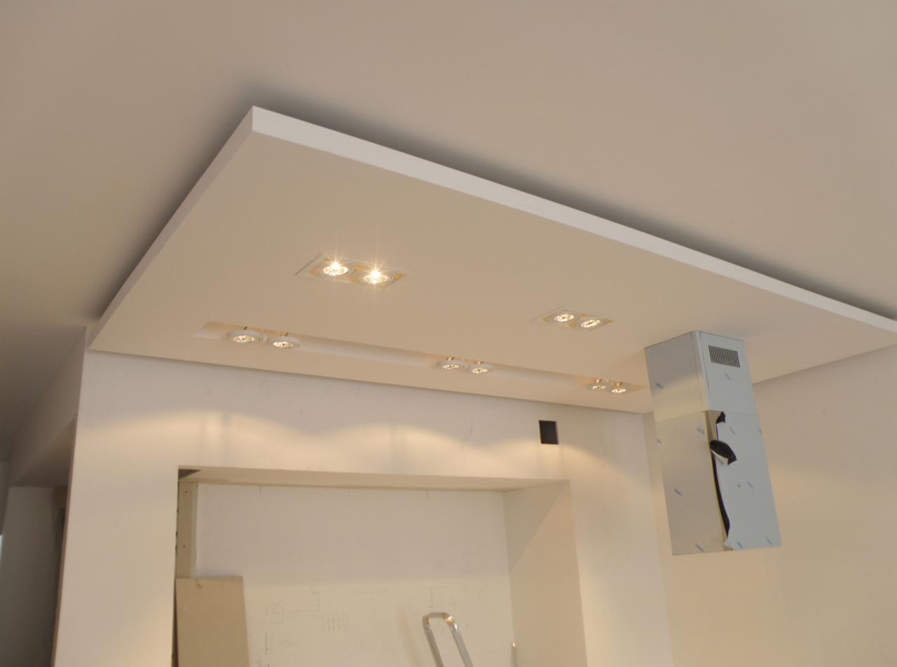 Nowoczesny sufit podwieszany z wbudowanym oświetleniem punktowym LED i systemem wentylacyjnym w pomieszczeniu w trakcie remontu, widoczny fragment ściany z przygotowaniem do malowania.