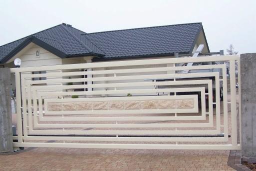 Nowoczesna brama wjazdowa z metalowymi, poziomymi profilami w kremowym kolorze i dekoracyjnym panelem z jasnego kamienia, na tle domu z ciemnym dachem.