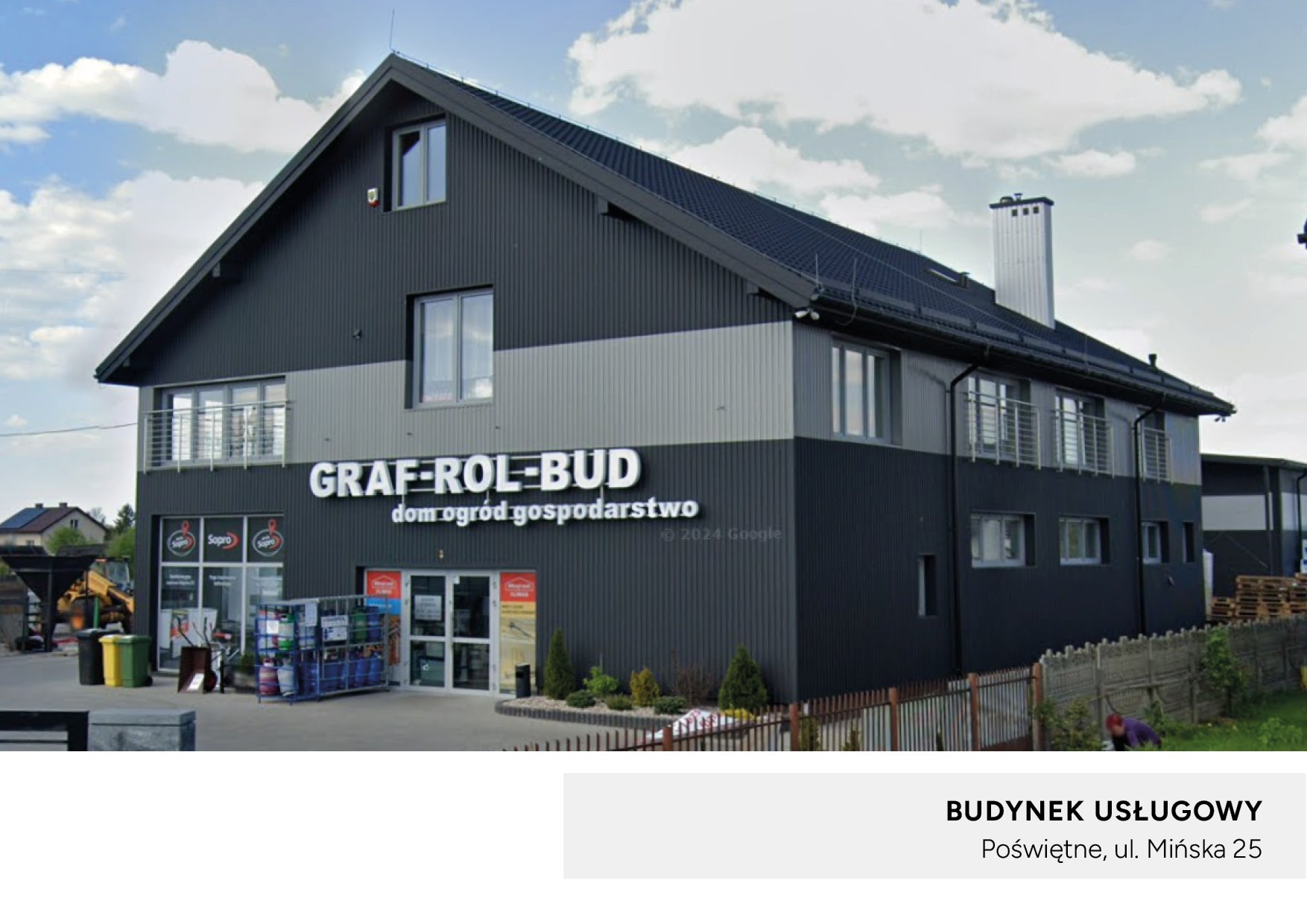 Dwukondygnacyjny budynek usługowy z szarej blachy falistej, z logo firmy 'GRAF-ROL-BUD dom ogród gospodarstwo' nad wejściem, widoczne towary na zewnątrz i koparka w tle.