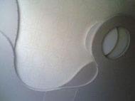 Biały sufit z ozdobnymi, asymetrycznymi wgłębieniami i wbudowanym oświetleniem punktowym, widoczne niedoskonałości w wykończeniu powierzchni.