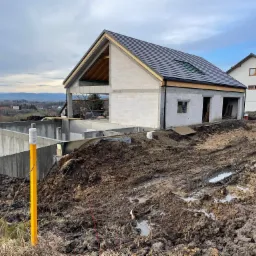 stan surowy otwarty domu z monolitycznym podpiwniczeniem na płycie fundamentowej wraz z murami oporowymi