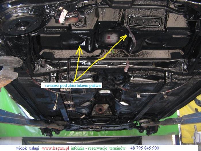 Podwozie samochodu po piaskowaniu i malowaniu proszkowym, widoczne elementy konstrukcyjne i przewody, wszystko pokryte czarną, błyszczącą powłoką ochronną.
