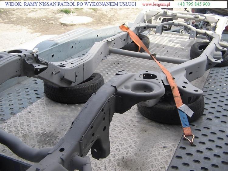 Szara rama Nissan Patrol po renowacji, zabezpieczona pomarańczowym pasem transportowym na metalowej platformie. Widoczne opony pod ramą.