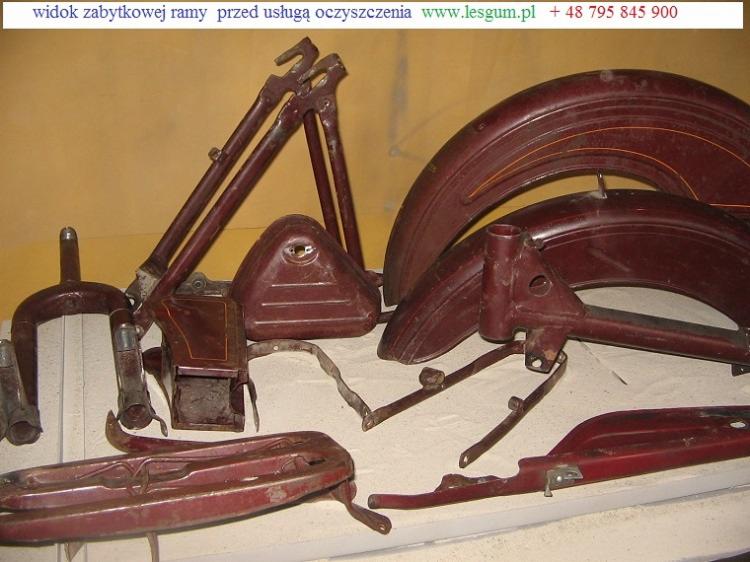 Zabytkowa rama motocykla w odcieniach bordo, przed procesem czyszczenia. Widoczne elementy takie jak błotniki, zbiornik i inne części składowe.
