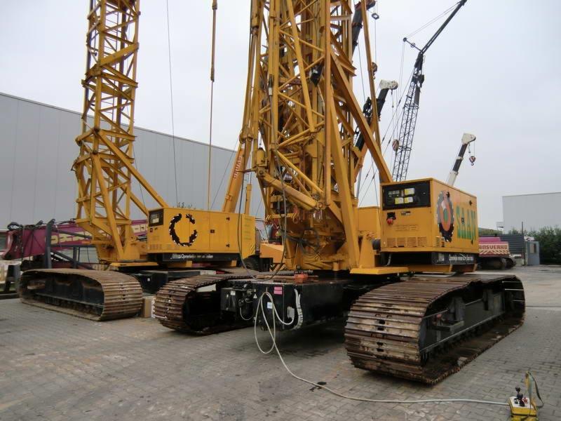 Dwa żółte dźwigi gąsienicowe Peiner CRL42-80 stoją obok siebie na betonowym placu, z widocznymi detalami konstrukcyjnymi i oznaczeniami firmy.