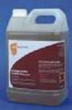 Kanister z brązowym płynem, etykieta z drobnym drukiem i logo w kolorze pomarańczowym, plastikowy uchwyt u góry, lekko zamglone tło.