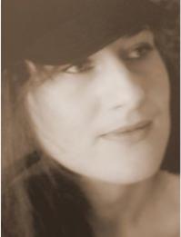 Portret kobiety w kapeluszu, stylizowany na sepię, z delikatnym uśmiechem, prawdopodobnie zdjęcie profilowe.