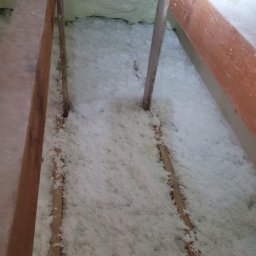 MARGIPS Marcin Biłgorajski - Poddasze ocieplone białą pianką PUR, widoczne drewniane elementy konstrukcji dachu.