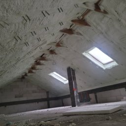 MARGIPS Marcin Biłgorajski - Poddasze po natrysku pianki izolacyjnej, widoczne krokwie, okna dachowe i ściany z bloczków, elementy montażowe w pianie.