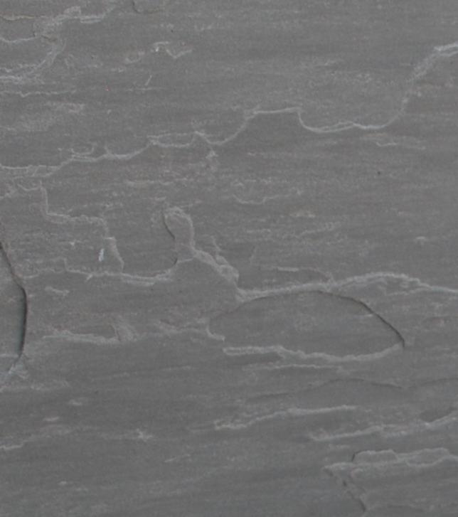 Szara, łupana powierzchnia kamienia elewacyjnego z wyraźną strukturą i nieregularnymi krawędziami.