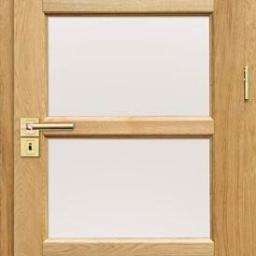 Innowacyjne Technologie S.C. Krzysztof Broma, Artur Walczak - Drewniane drzwi wewnętrzne z trzema szybami, widoczna złota klamka i zawiasy, jasne drewno dębowe.