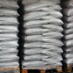 Trzy palety z workami ekogroszku, owinięte folią stretch, widoczne w magazynie.