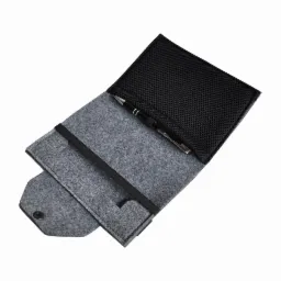 Otwarty szary filcowy futerał z czarną siatką wewnątrz, zawierający długopis z metalowymi elementami.