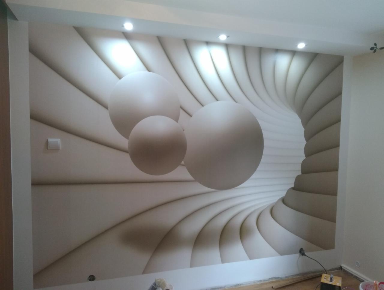 Fototapeta z motywem trójwymiarowego tunelu i kul w jasnych, stonowanych barwach na ścianie w pokoju, widoczny fragment podłogi z akcesoriami.