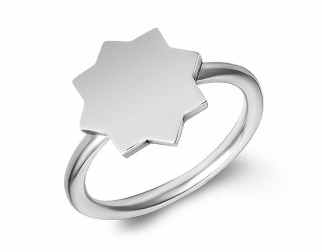 Błyszczący, srebrny pierścionek z geometrycznym, ośmioramiennym elementem centralnym na białym tle.