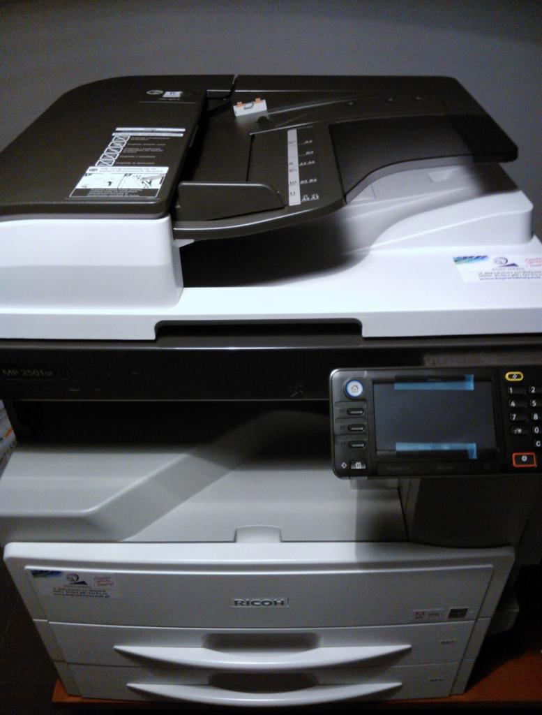 Nowa kserokopiarka Ricoh Aficio MP 2001L A3, widok z przodu, z panelem sterowania po prawej stronie, na tle szarej ściany.