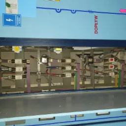 Otwarta szafa rozdzielcza z bezpiecznikami i okablowaniem w Sosnowcu, widoczne oznaczenia dopływu z stacji ST-C 14 oraz tabliczka 'Wyłącznik główny'.