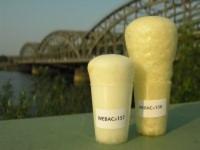 Dwa plastikowe pojemniki z żółtawą pianą poliuretanową WEBAC 151, o różnej wysokości, na tle rzeki i metalowego mostu.