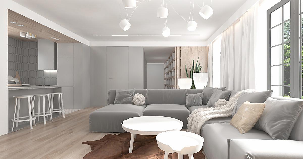 Jasne, przestronne wnętrze z szarą sofą modułową, białymi stolikami kawowymi, drewnianą podłogą i otwartą kuchnią w tle, oświetlone nowoczesnymi lampami wiszącymi.