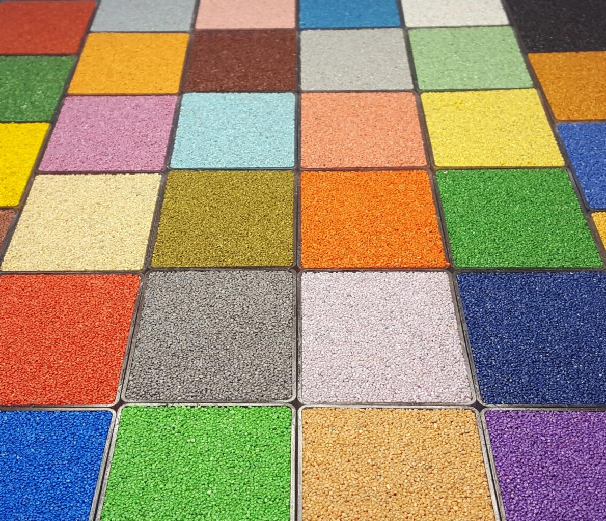 Paleta kolorów nawierzchni z drobnych kruszyw w kwadratowych próbkach, widok z góry, różnorodność barw od zieleni po fiolety.