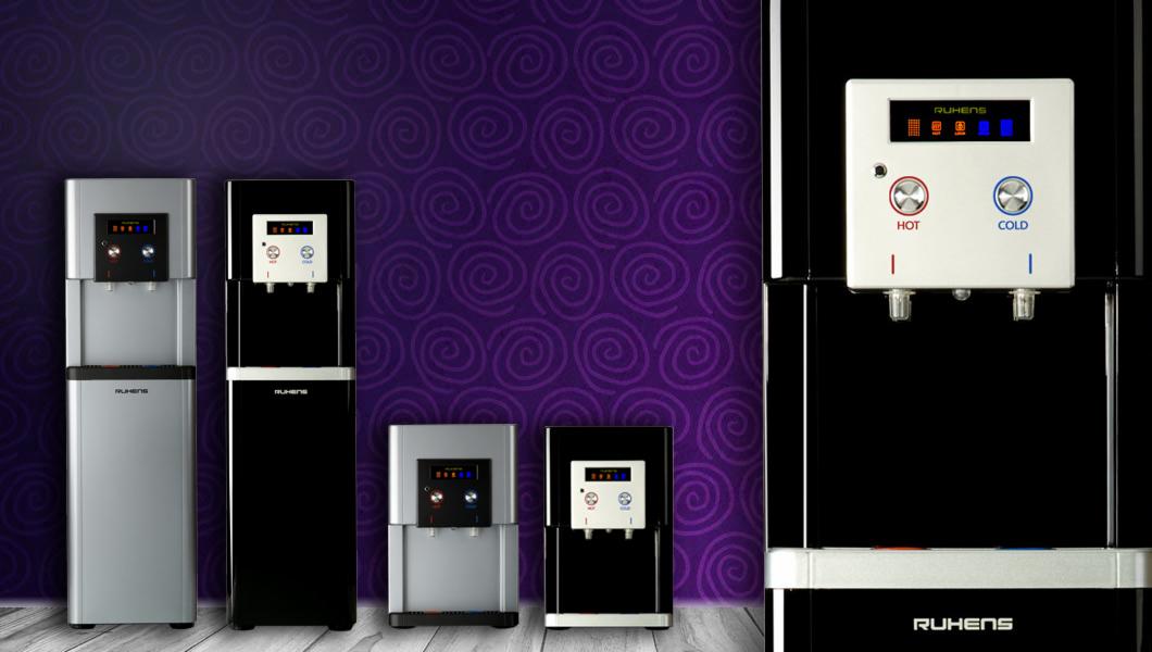 Rzędy dystrybutorów wody Ruhens w kolorze czarnym i srebrnym na tle fioletowej ściany z motywem spiralnym.