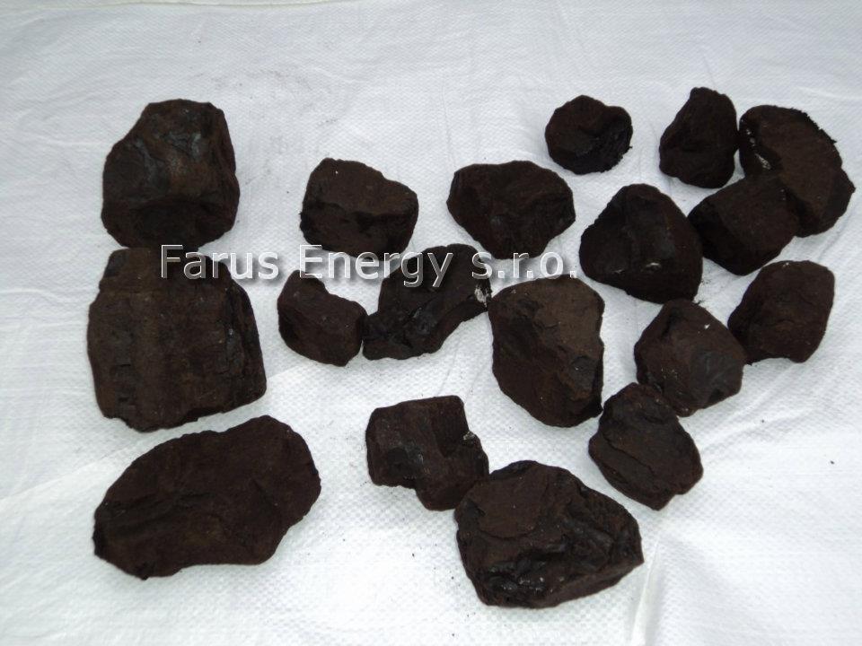 Kawałki węgla typu orzech na białym tle, widoczne nieregularne kształty i matowa powierzchnia.