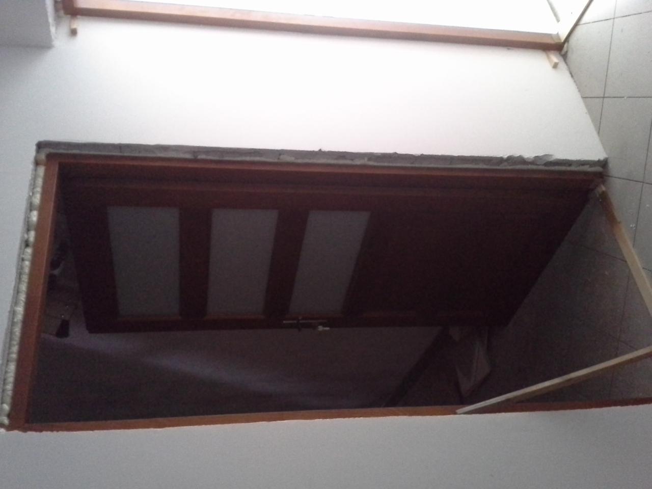 Otwór w ścianie z widoczną futryną, przygotowany do montażu drzwi. Ściana w trakcie wykończenia, widoczne nierówności i surowy stan.