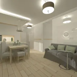 Jasne, przestronne wnętrze z drewnianą podłogą, szarą sofą z zielonymi poduszkami, stołem jadalnym z krzesłami i aneksem kuchennym w tle, oświetlone nowoczesnymi lampami sufitowymi.