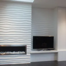 Nowoczesna ściana z panelami 3D w salonie. Dekoracyjny kominek z białymi kamieniami, telewizor i biała zabudowa meblowa. Minimalistyczny design.