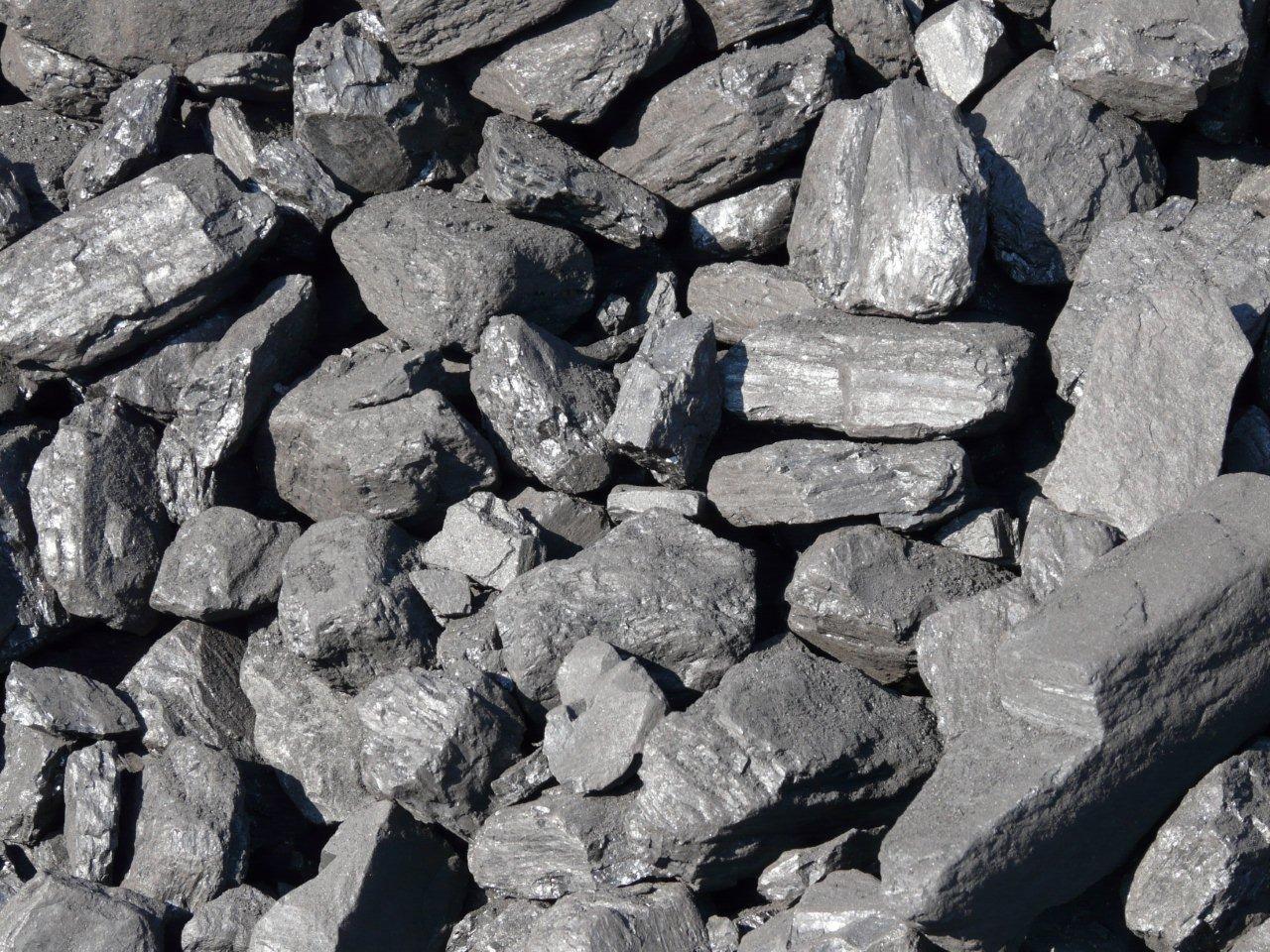 Góra węgla orzech o nieregularnych kształtach, z widocznymi refleksami światła na niektórych bryłach.